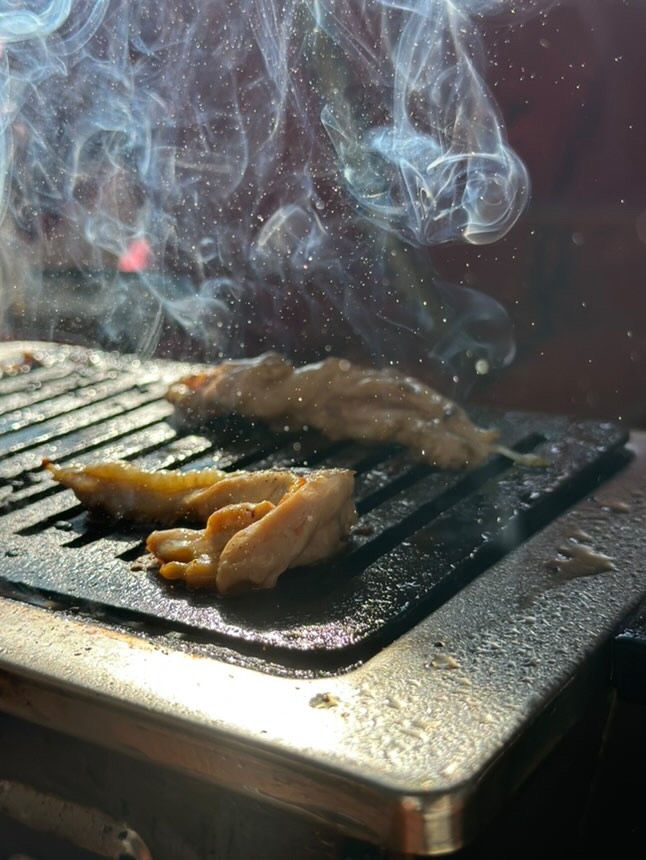 煙が上がる焼肉の網焼き